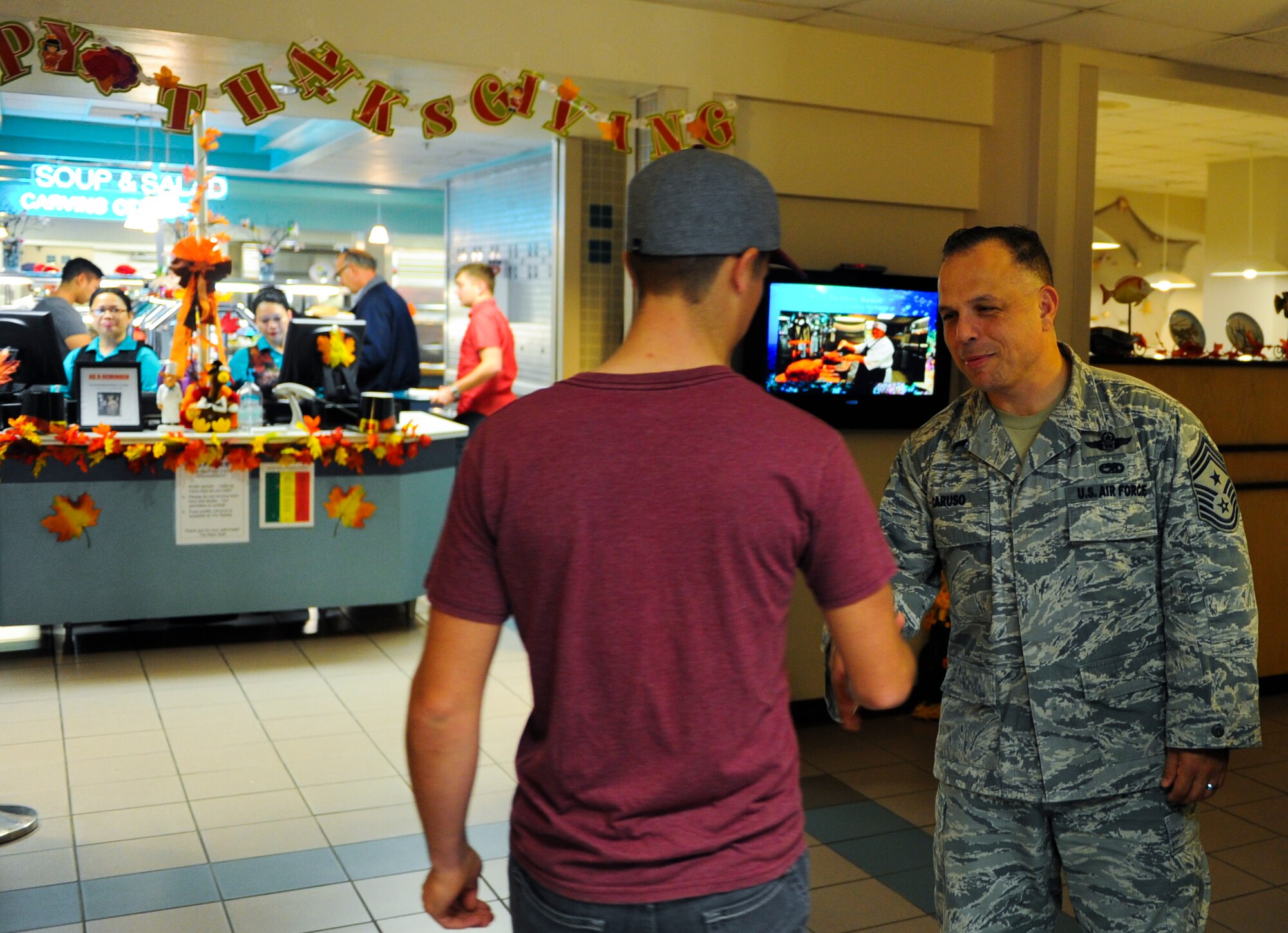 Chief Master Sgt. Matthew Caruso, Air Force Special Operations Command command chief, greets an Air Commando at the Reef Dining Facility during Thanksgiving lunch at Hurlburt Field, Fla., Nov. 27, 2014. Leadership from the Air Force Special Operations Command and 1st Special Operations Wing served Air Commandos and retirees during the lunch. (U.S. Air Force photo/Senior Airman Christopher Callaway)
