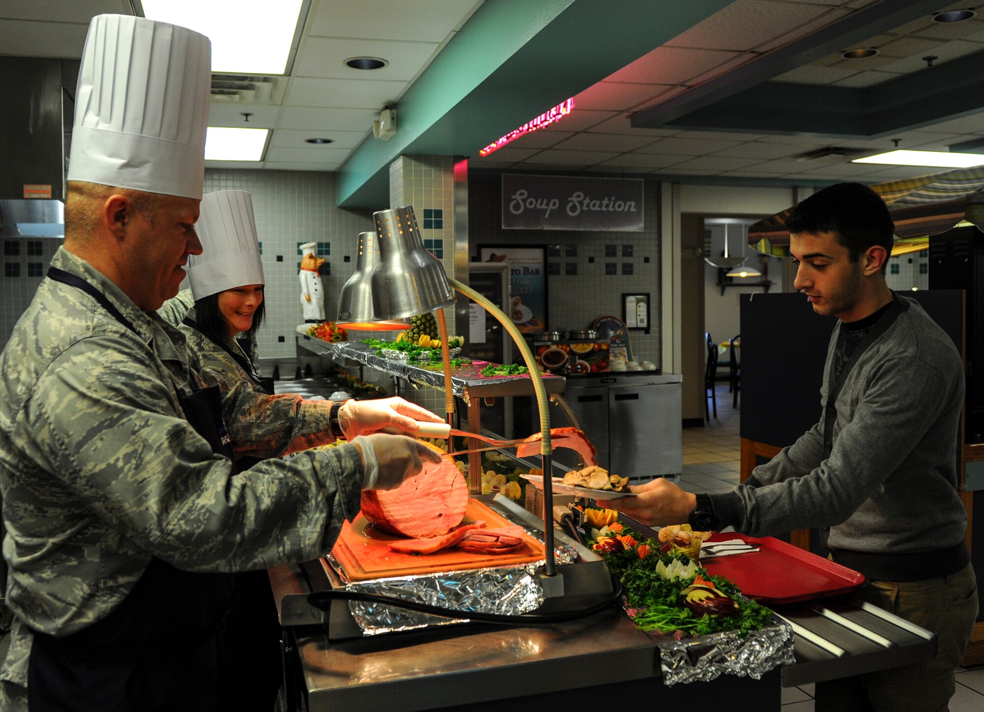 Lt. Col. Paul Brister, 23rd Special Tactics Squadron commander, serves ham to Airman 1st Class Miguel Bargas during Thanksgiving lunch at the Reef Dining Facility on Hurlburt Field, Fla., Nov. 27, 2014. Leadership from the Air Force Special Operations Command and 1st Special Operations Wing served Air Commandos and retirees during the lunch. (U.S. Air Force photo/Senior Airman Christopher Callaway)