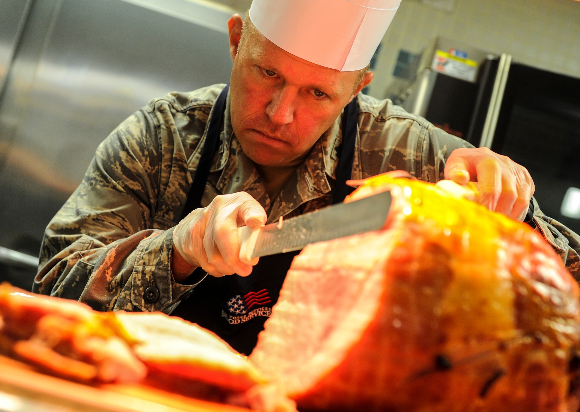 Lt. Col. Paul Brister, 23rd Special Tactics Squadron commander, serves ham during Thanksgiving lunch at the Reef Dining Facility on Hurlburt Field, Fla., Nov. 27, 2014. Leadership from the Air Force Special Operations Command and 1st Special Operations Wing served Air Commandos and retirees during the lunch. (U.S. Air Force photo/Senior Airman Christopher Callaway)