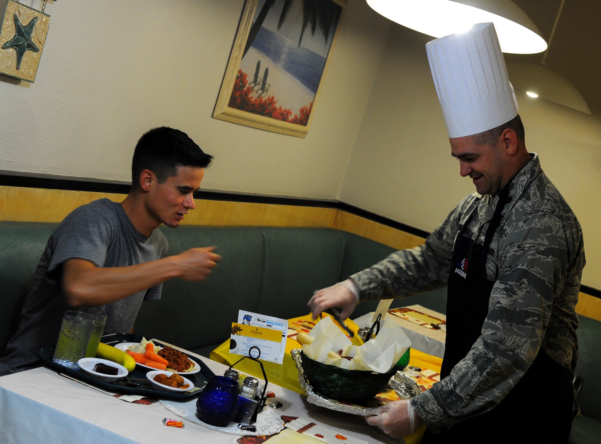 Maj. James Cunningham, 1st Special Operations Comptroller Squadron commander, serves breadsticks to Senior Airman Sean Whealton, 4th Aircraft Maintenance Unit, during Thanksgiving lunch at the Reef Dining Facility on Hurlburt Field, Fla., Nov. 27, 2014. Leadership from the Air Force Special Operations Command and 1st Special Operations Wing served Air Commandos and retirees during the lunch. (U.S. Air Force photo/Senior Airman Christopher Callaway)