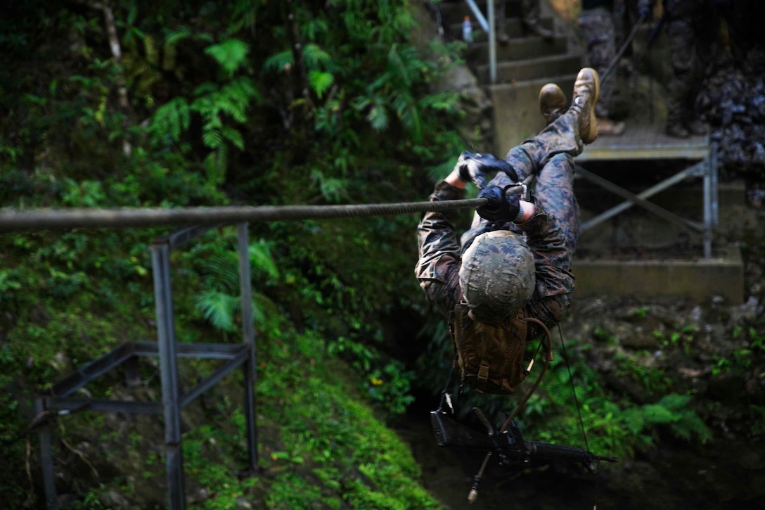 CAMP GONSALVES, Japan – Samuel C. Mills, from Lawrenceville, Georgia, crosses a river obstacle Nov. 25 while going through the Jungle Warfare Training Center’s endurance course on Camp Gonsalves. “The endurance course is used to build camaraderie and small unit leadership,” said Mills. “The course forces squads to work together or else they will completely fall apart.” Mills is a fire support man with 1st Battalion, 1st Marine Regiment, currently assigned to 4th Marine Regiment, 3rd Marine Division, III Marine Expeditionary Force, under the unit deployment program. 