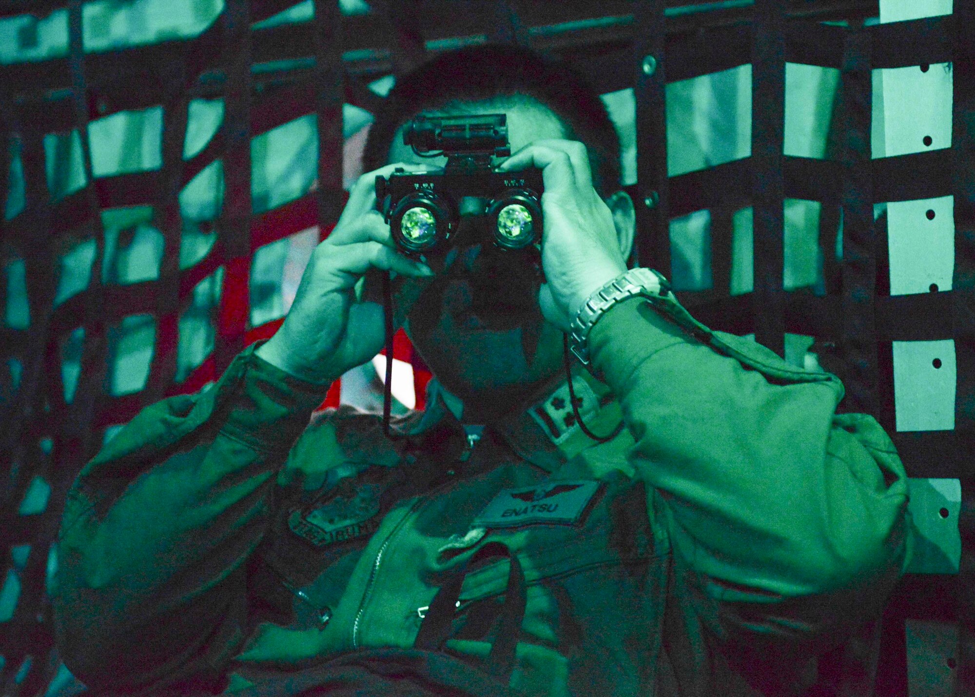 A Japan Air Self-Defense Force Airman looks through a pair of night vision goggles inside a C-130 Hercules during KEEN SWORD 2015 at Yokota Air Base, Japan, Nov. 13, 2014.  Several JASDF Airmen had the opportunity to participate in a Low-Cost, Low-Altitude drop a night flight operations.  (U.S. Air Force photo by Airman 1st Class Soo C. Kim / Released)
