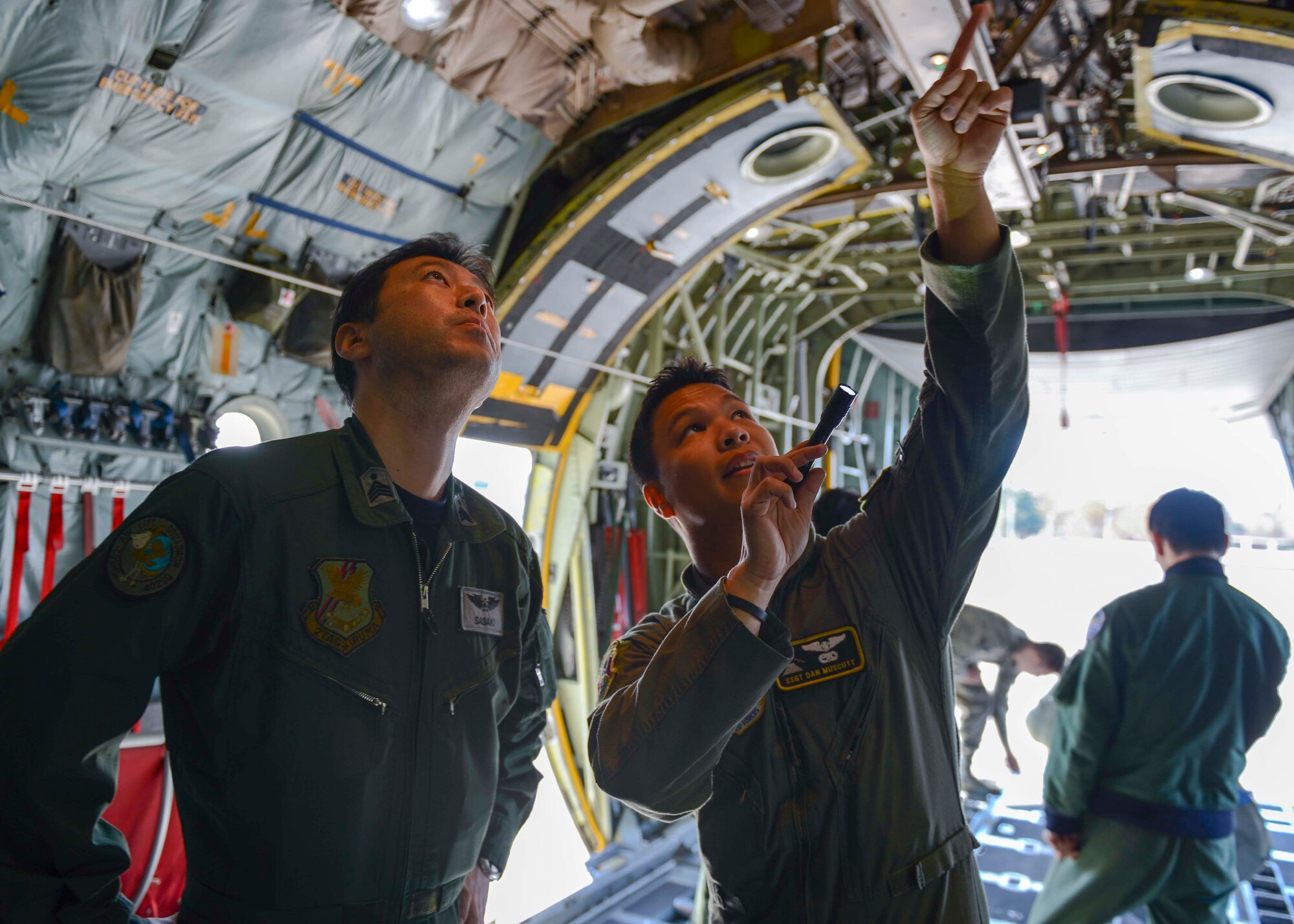 Staff Sgt. Dan Muscutt, 36th Airlift Squadron loadmaster, explains different functions around a C-130 Hercules to a Japan Air Self-Defense Force Airman during KEEN SWORD 2015 at Yokota Air Base, Japan, Nov. 13, 2014.  KEEN SWORD is a bilateral exercise between the U.S. military and Japan, aimed to increase readiness to respond to varied crisis situations in the Pacific theater.  (U.S. Air Force photo by Airman 1st Class Soo C. Kim / Released)