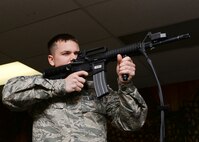 Airman 1st Class James Ash, 28th Operations Support Squadron aircrew flight equipment technician, tests his accuracy on the Fire Arm Training Simulator during a use of force training session at Ellsworth Air Force Base, S.D., Nov. 18, 2014. The F.A.T.S. machine conducts simulated shoot and no-shoot scenarios, testing a person’s overall capability to respond to simulated threats. (U.S. Air Force photo by Senior Airman Anania Tekurio/Released)  
