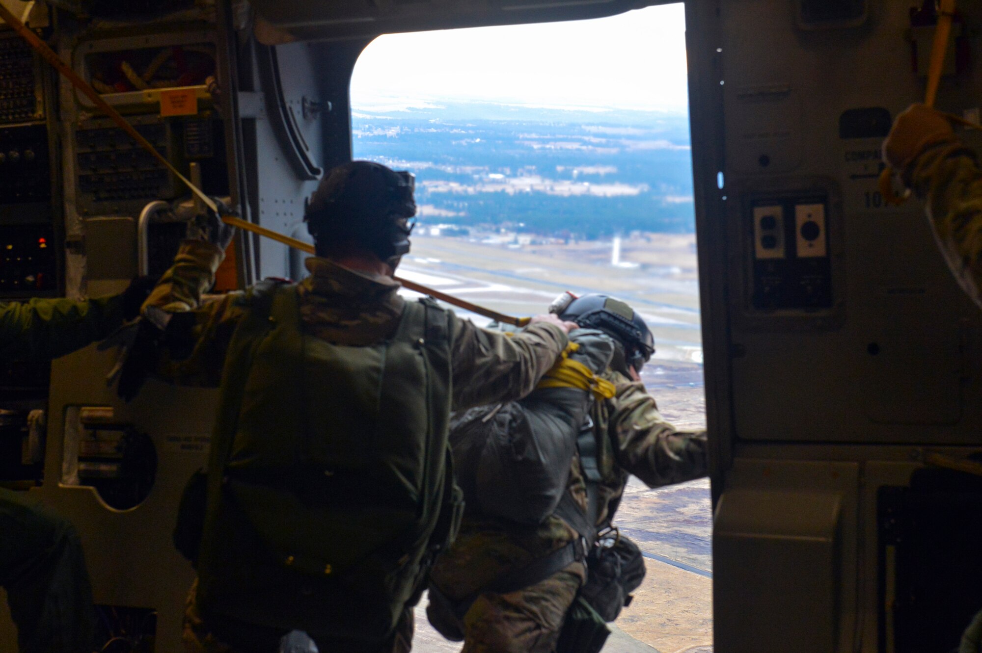 Staff Sgt. Raymond Caballero-Perez (right), 22nd Training Squadron parachuting shop NCO in charge, searches for the drop zone prior to his Airmen performing static line jump training from a McChord Field C-17 Globemaster III Nov. 24, 2014, at Fairchild Air Force Base, Wash. The 22nd TRS Airmen were prepared for four static line jumps and two high altitude, low opening jumps during the day of training with the McChord crew. (U.S. Air Force photo/Staff Sgt. Russ Jackson)