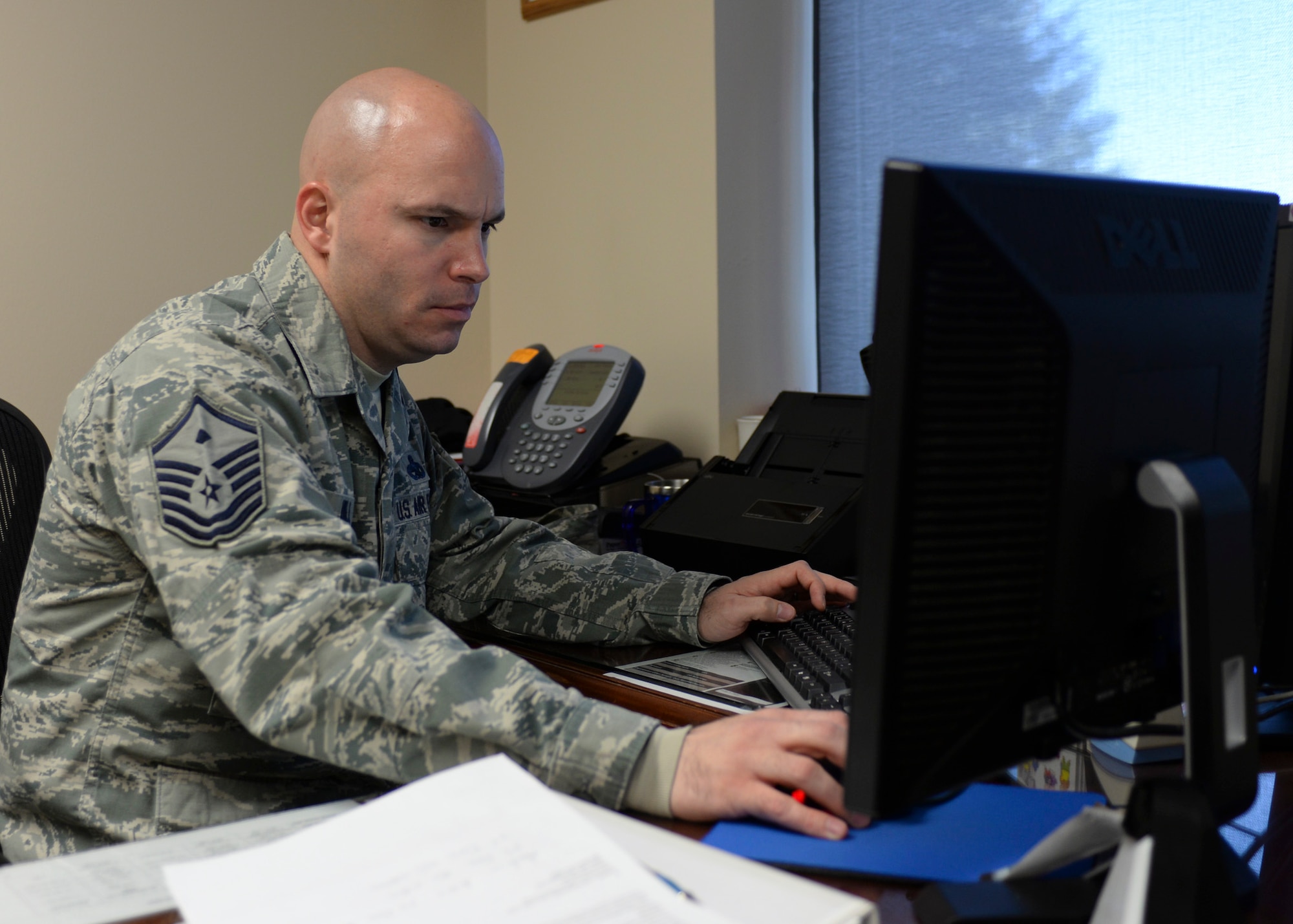 Master Sgt. Patrick Hill, 28th Medical Group first sergeant, updates paperwork and responds to base personnel inquiries at his workstation at Ellsworth Air Force Base, S.D., Nov. 13, 2014. As a first sergeant, much of each day is dedicated to staying informed and properly responding to Airmen’s needs. (U.S. Air Force photo by Senior Airman Anania Tekurio/Released) 