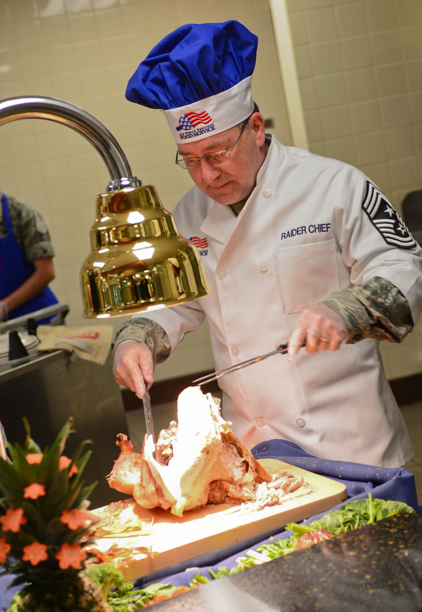 Chief Master Sgt. Kevin Peterson, 28th Bomb Wing command chief, serves Airmen a large turkey dinner at the Raider Café dining facility at Ellsworth Air Force Base, S.D., Nov. 27, 2014. This holiday meal is an annual event where base leaders from around Ellsworth gather to share Thanksgiving with Airmen that may not have had an opportunity to go home during the holidays. (U.S. Air Force photo by Senior Airman Zachary Hada/Released)
