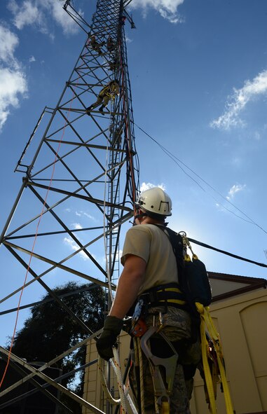 Staff Sgt. John Hines, 2nd Communications Squadron cable and antenna systems, holds a safety line as an Airman scales a communications tower on Barksdale Air Force Base, La., Nov. 19, 2014. Hines acted as a safety observer, who alerts climbers of any dangers or hazards, assists climbers with tools and provides medical assistance in the event of a mishap. (U.S. Air Force photo/Senior Airman Benjamin Gonsier)