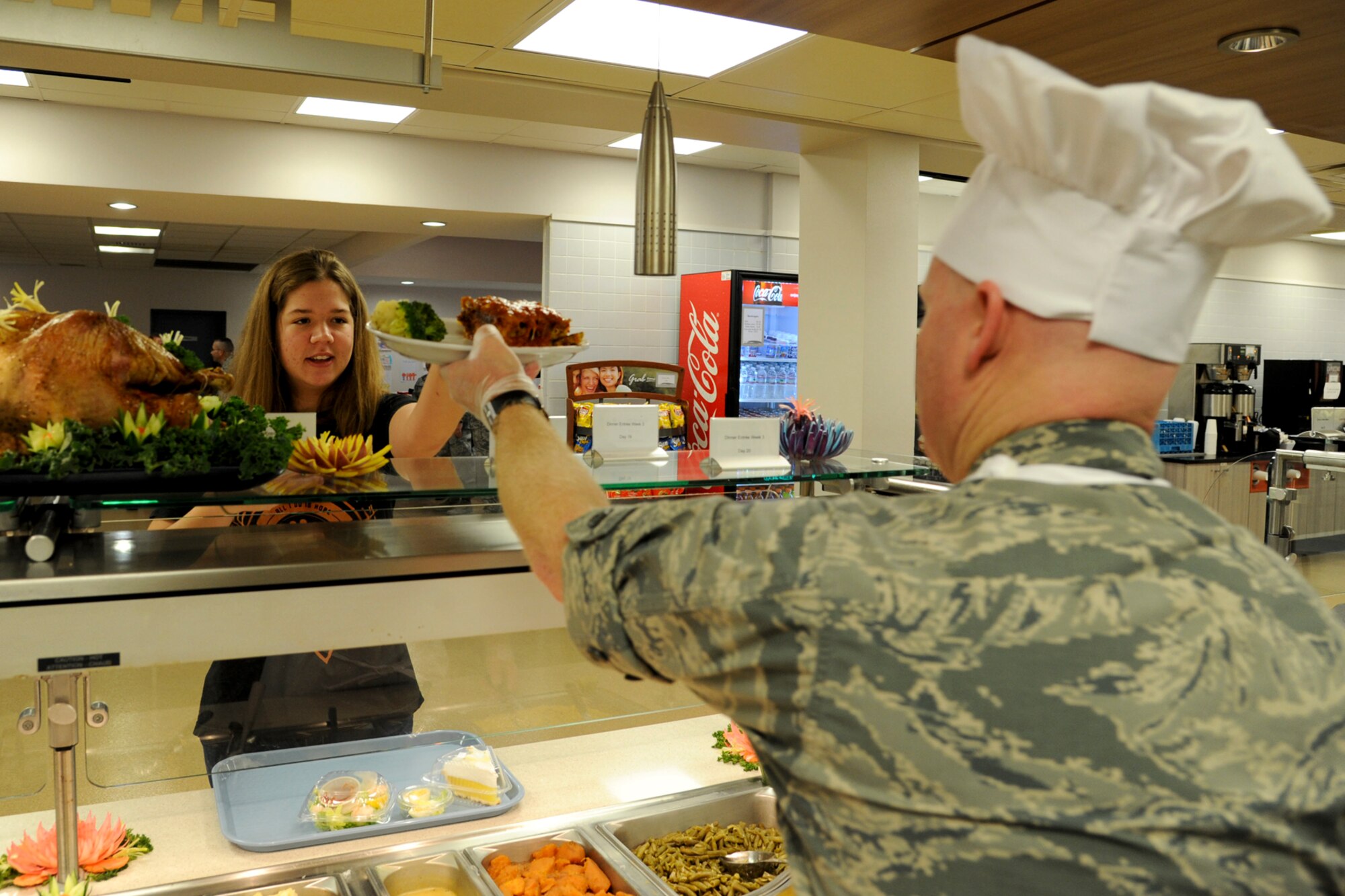 Maj. Daniel Willison, 2nd Maintenance Squadron commander, serves Airman 1st Class Alexis Zirbel, 2nd Operations Support Squadron, during the Red River Dining Facility Thanksgiving lunch on Barksdale Air Force Base, La., Nov. 27, 2014. More than twenty base leaders volunteered to serve food to Airmen, retirees and dependents. (U.S. Air Force photo/ Senior Airman Jannelle Dickey)