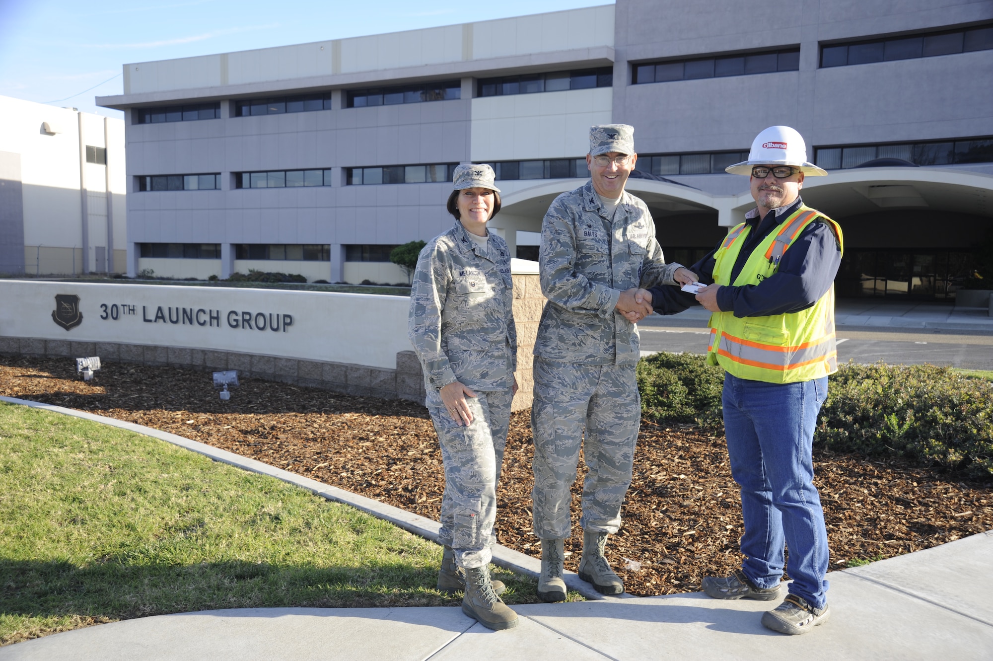 U.S. Air Force Col. Keith W. Balts, commander, 30th Space Wing and Col. Patrice Melancon, 614th Air Operations Center, 14th Air Force (Air Forces Strategic) and Joint Functional Component Command for Space headquarters consolidation program manager, turned over control of Building 7015 on Vandenberg Air Force Base, Calif., to Mr. Tony Strickroth, senior project manager for the Gilbane Corporation, the construction and renovation contractor for the consolidation project, Nov. 3, 2014. The 614th AOC, 14 AF and JFCC Space consolidation project will provide a more effective and resilient mission platform for the Joint Space Operations Center, while also co-locating the 14 AF and JFCC Space headquarters elements with their operations center, improving the synergistic delivery of global space effects.  (U.S. Air Force photo by Airman 1st Class Ian Dudley/Released)