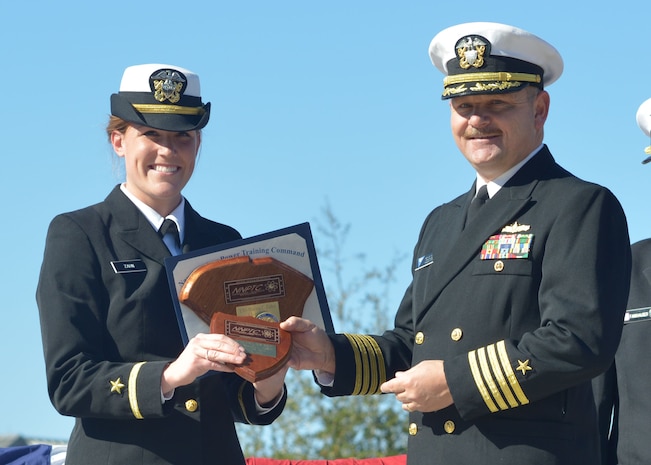 Captain Ace Van Wagoner, Commander Naval Air Forces U.S. Atlantic Fleet Force Nuclear Propulsion officer, presents Ens. Marisa Zahn with a plaque in recognition of her being named the officer class honor graduate at the Naval Nuclear Power Training Command graduation Nov. 21, 2014 at Joint Base Charleston, S.C. Van Wagoner was the guest speaker during the ceremony. (U.S. Navy photo/Petty Officer 2nd Class Jason Pastrick)