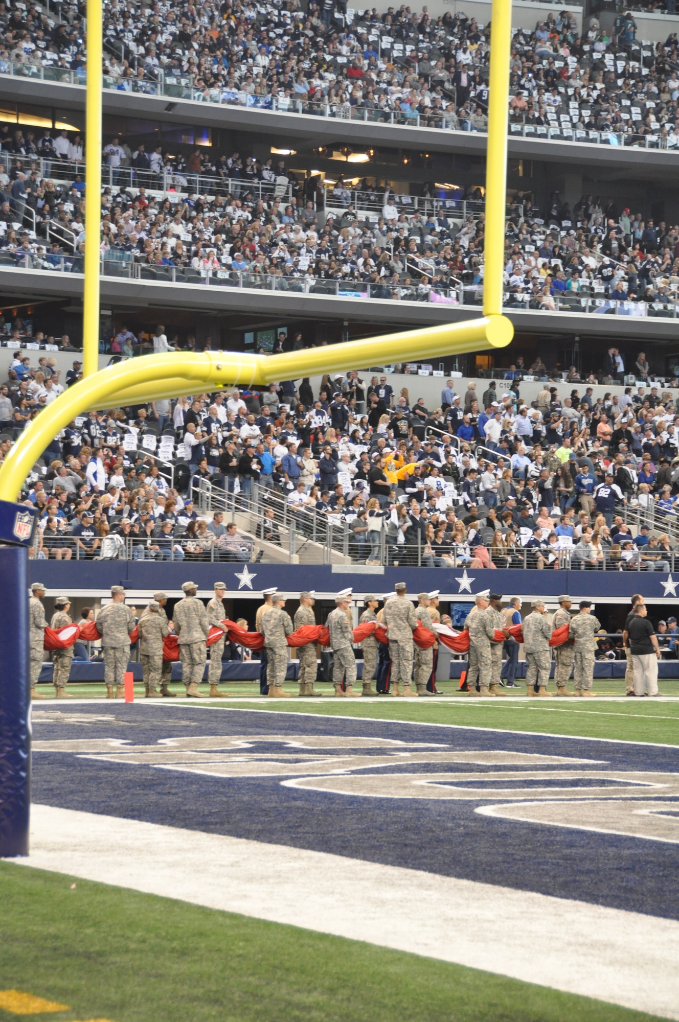 NAVAL AIR STATION FORT WORTH JOINT RESERVE BASE, Texas - Approximately 75 servicemembers hold a large American flag before taking their position on the field for the playing of the National Anthem during the Dallas Cowboys' Thanksgiving game at AT&T Stadium, Arlington, Texas Nov. 27, 2014. (U.S. Air Force photo/Capt. Candice Allen)