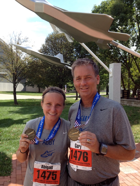 U.S. Air Force 2nd Lt. Abigail Webber, 633rd Inpatient Squadron labor and delivery nurse, poses for a photo with her father, U.S. Air Force retired Col. (Dr.) Gary Frederickson, after running the 2012 Air Force Marathon at Wright-Patterson Air Force Base. Webber continues to run with her dad every week at her current duty station, Langley Air Force Base. (U.S. Air Force courtesy photo/Released)  