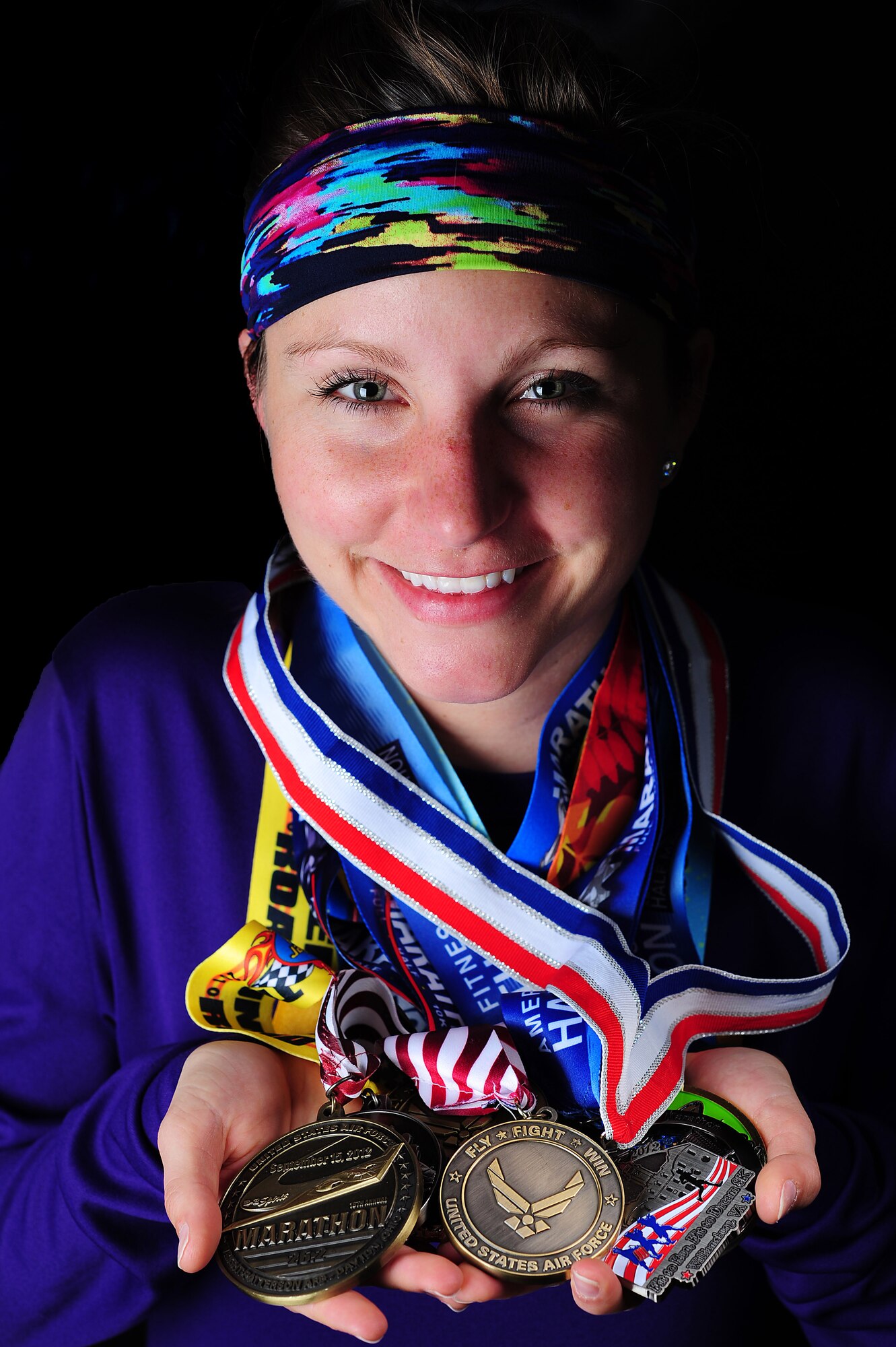 U.S. Air Force 2nd Lieutenant Abigail Webber, 633rd Inpatient Squadron labor and delivery nurse, dons medals from past half and full marathons, Nov. 19, 2014, at Langley Air Force Base, Va.  Webber started running after her sister joined a cross country team, and since then, it has become a family activity. Both Webber and her sister, Holly, have ran half and full marathons with their father, retired U.S. Air Force Col. (Dr.) Gary Frederickson. (U.S. Air Force photo by Staff Sgt. Natasha Stannard/Released)  