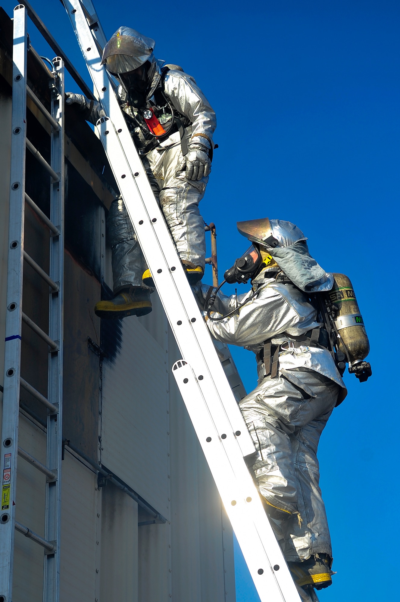 Firemen from the 4th Civil Engineer Squadron climb a ladder during a simulated fire exercise held during exercise Coronet Warrior 14-03 at Seymour Johnson Air Force Base, North Carolina, Nov. 20, 2014. The 4th Fighter Wing regularly conducts exercises like Coronet Warrior to prepare Airmen for contingency operations in deployed environments. (U.S. Air Force photo/Airman Shawna L. Keyes)