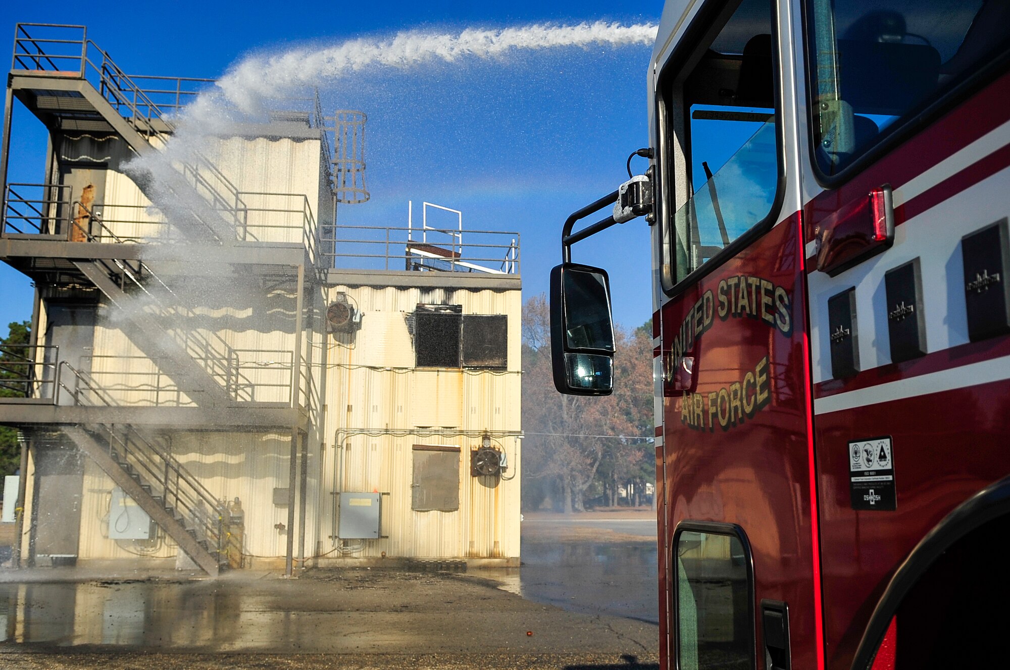 An aircraft rescue firefighting truck prays down the firemen’s training building during a simulated fire as part of the exercise Coronet Warrior 14-03 at Seymour Johnson Air Force Base, North Carolina, Nov. 20, 2014. Coronet Warrior tested Airmen on their response to different scenarios to prepare them for contingency operations in deployed environments. (U.S. Air Force photo/Airman Shawna L. Keyes)