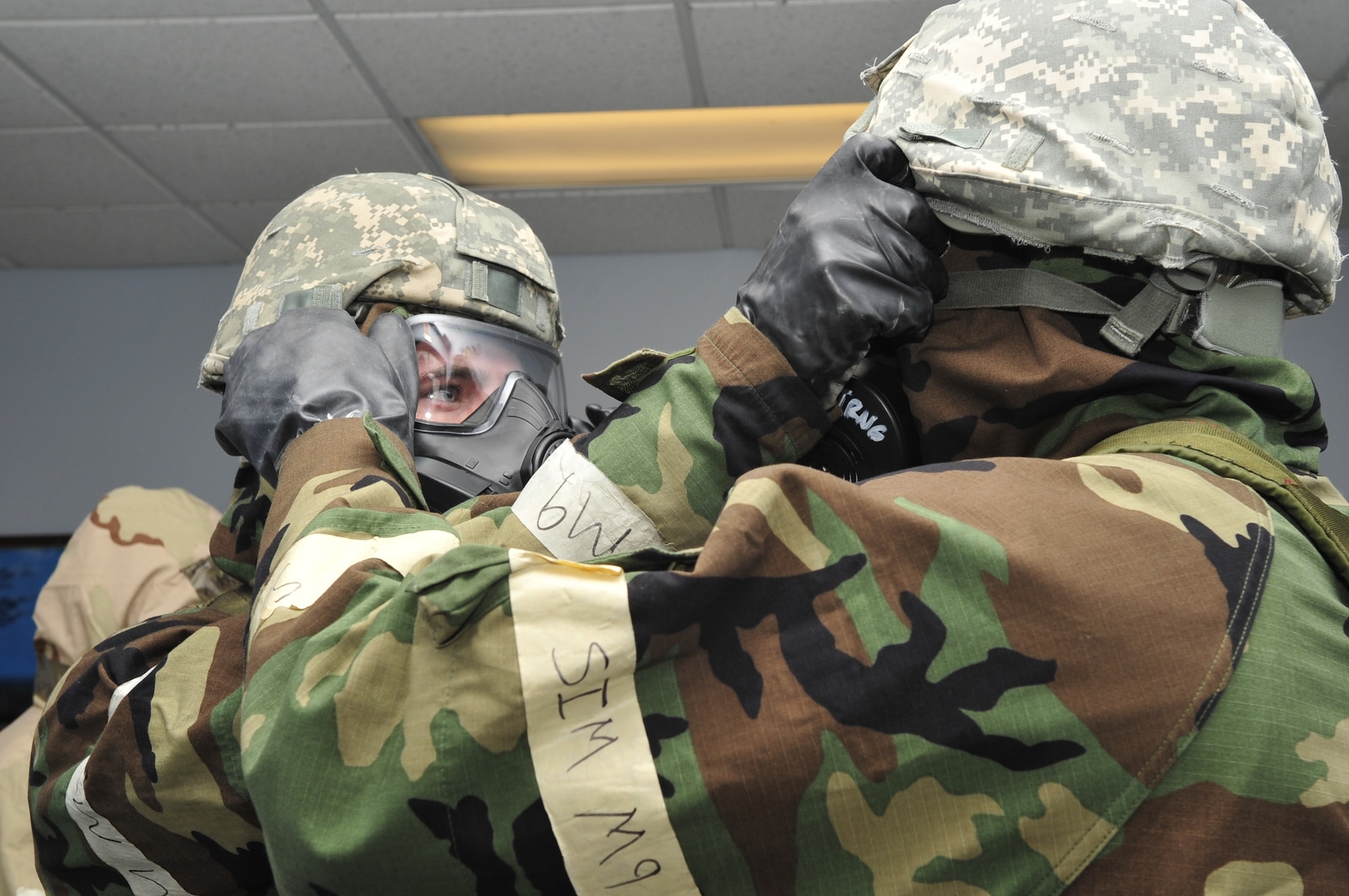 Airmen perform buddy checks during an Ability To Survive and Operate rodeo as part of exercise Coronet Warrior 14-03 at Seymour Johnson Air Force Base, North Carolina, Nov. 17, 2014. ATSO rodeo participants donned chemical protective gear, covered assets with protective plastic sheathing, and performed post-attack reconnaissance sweeps to practice surviving in a chemical threat environment. (U.S. Air Force photo/Airman Shawna L. Keyes)