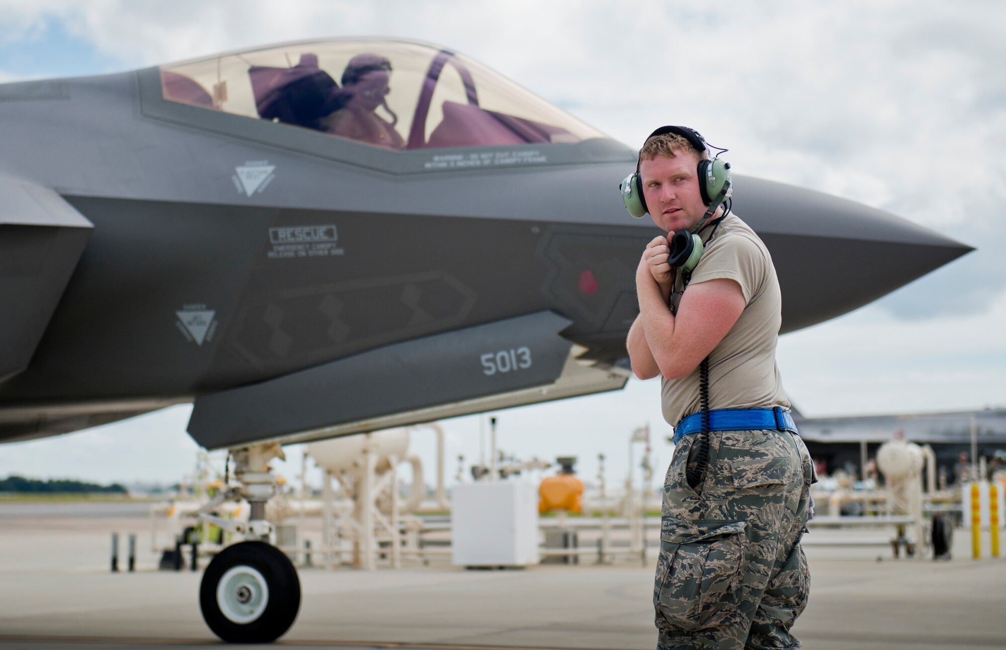 Senior Airman Herbert Tucker, 33rd Aircraft Maintenance Squadron, checks his six before marshalling out a refueled F-35A Lightning II at Eglin Air Force Base, Fla.  All of the F-35 variants use the refueling areas in conjunction with the 96th Logistics Readiness Squadron’s fuels flight. (U.S. Air Force photo/Samuel King Jr.)  