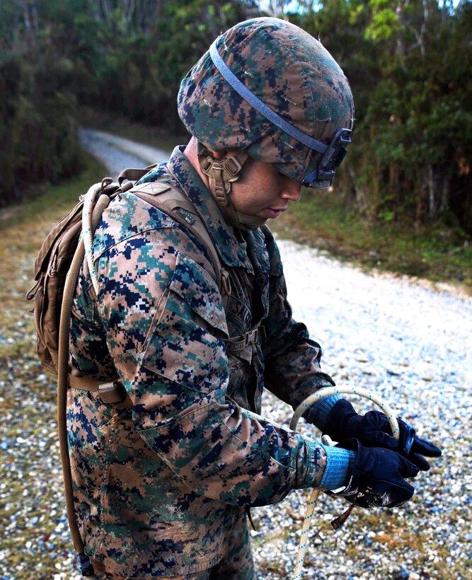 U.S. Marine Corps Lance Cpl. Ricky Salgado ties a harness for himself before he crosses a rope bridge as part of the endurance course at the Jungle Warfare Training Center on Camp Gonsalves, Okinawa, Japan, Nov. 25, 2014. Salgado is a rifleman assigned to the 1st Battalion, 1st Marine Regiment, currently assigned to the 4th Marine Regiment, 3rd Marine Division, III Marine Expeditionary Force.