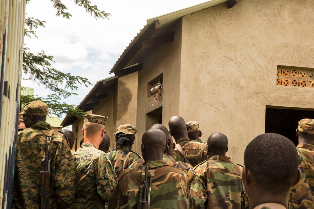 Explosive Ordnance Disposal Technicians discuss possible IED hiding places with members of the Uganda People’s Defense Force (UPDF) in Camp Singo, Uganda, Nov. 4, 2014. The EOD Technicians are part of a team of Marines and Sailors from SPMAGTF-Crisis Response-Africa working alongside the UPDF, helping hone their skills in countering-improvised explosive devices during a logistics and engineering training engagement. (U.S. Marine Corps photo by Cpl. Shawn Valosin)