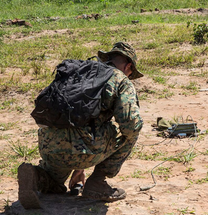 An Explosive Ordnance Disposal Technician readies a charge during a Counter-IED course in Camp Singo, Uganda, Nov. 4, 2014. Explosive Ordnance Disposal Technicians with SPMAGTF-Crisis Response-Africa detonated multiple explosive devices to show how powerful and dangerous IEDs of different sizes can be. (U.S. Marine Corps photo by Cpl. Shawn Valosin)