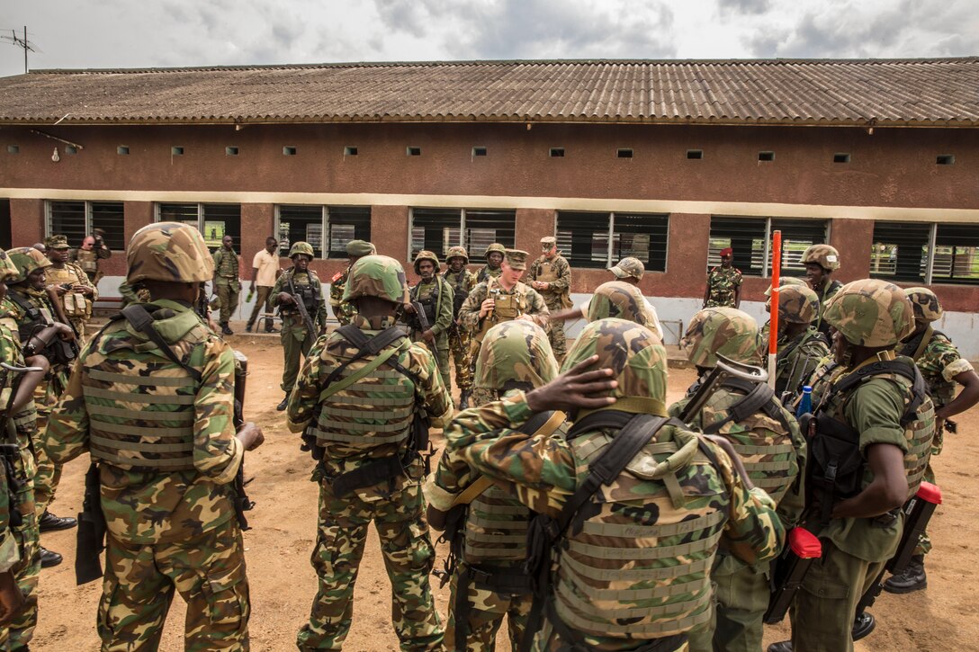 Sergeant Jay Schenkel II speaks with soldiers with the Burundi National Defense Force (BNDF) after conducting practical application drills for improvised explosive device sweeping while patrolling in Bujumbura, Burundi, Nov. 6, 2014. Schenkel is an explosive ordnance disposal technician with SPMAGTF-Crisis Response-Africa training alongside the BNDF, teaching basic infantry tactics, engineering, logistical support, countering-IED, lifesaving techniques and convoy operations to prepare them for an upcoming deployment in support of the African Union Mission in Somalia (AMISOM). (U.S. Marine Corps photo by Cpl. Shawn Valosin)