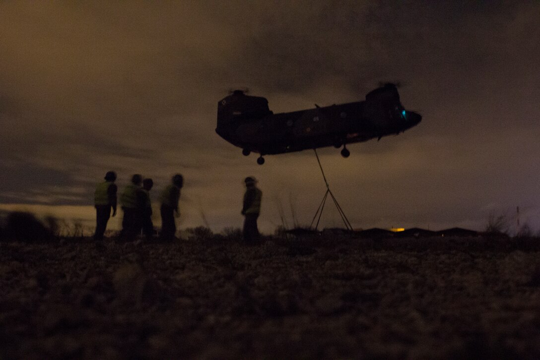 U.S. Marines with SPMAGTF Crisis Response - Africa and Spanish soldiers with Transport Helicopter Battalion 5, prepare to sling a truck to the bottom of the Spanish Army CH-47 Chinook, at Colmenar de Viejo, Spain, Nov. 19, 2014. The long distance transportation of vehicles by air can be used when conducting a disaster relief mission where vehicles are needed but key road and bridges are destroyed. The training conducted by the Marines and soldiers enhanced mission readiness and help build relationships between the two militaries. (U.S. Marine Corps photo by Cpl Jeraco Jenkins/Released).