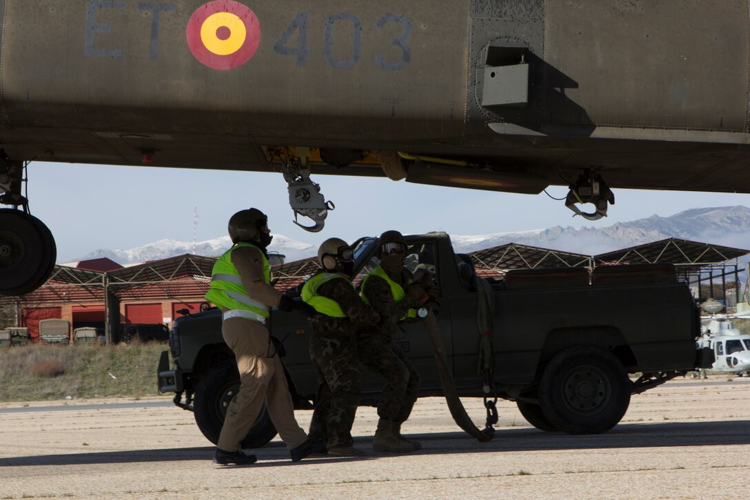 U.S. Marines with SPMAGTF Crisis Response - Africa and Spanish soldiers with Transport Helicopter Battalion 5, ground static electricity from the aircraft and prepare to sling two water bladders to the bottom of the Spanish Army CH-47 Chinook, at Colmenar de Viejo, Spain, Nov. 18, 2014. The 4,300 pound water bladders can be used to transport clean water to support troops operating in a location without potable water or when conducting humanitarian assistance missions. The training enhanced mission readiness and help build relationships between the two militaries. (U.S. Marine Corps photo by Cpl. Jeraco Jenkins/Released)