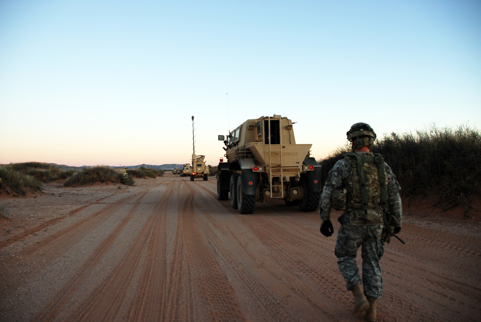 A Soldier from the Wisconsin Army National Guard’s 950th Engineer Company moves between vehicles during a training mission Nov. 24, 2014, at Fort Bliss, Texas. The 950th is training to conduct a route clearance mission in Afghanistan. 