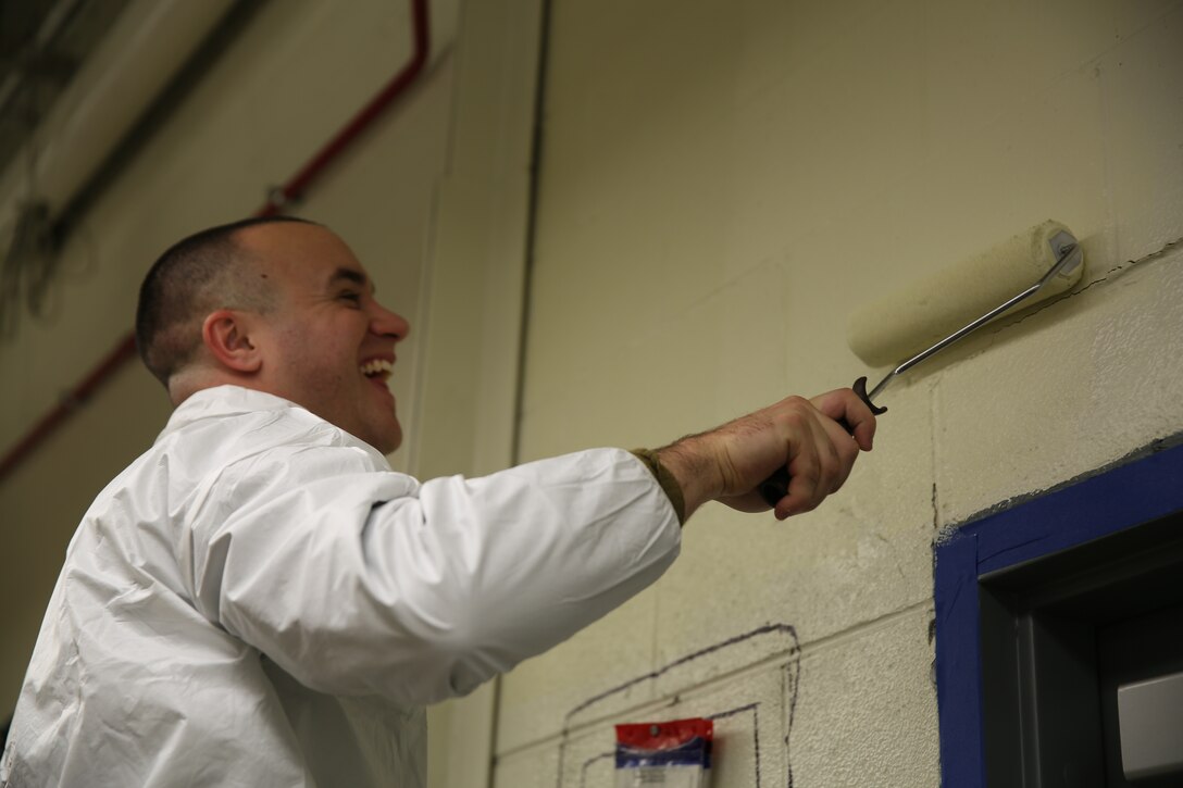 Cpl. Joseph Stabile paints a wall during renovations to the Marine Transport Squadron 1 hangar at Marine Corps Air Station Cherry Point, N.C., Nov. 24, 2014. The Marines of VMR-1 pitched in to assist with recent renovations to the aging structure, improving their working conditions, increasing energy efficiency and saving tens of thousands of dollars in the process. Stabile is an avionics technician with VMR-1 and native of Perth Amboy, N.J. 