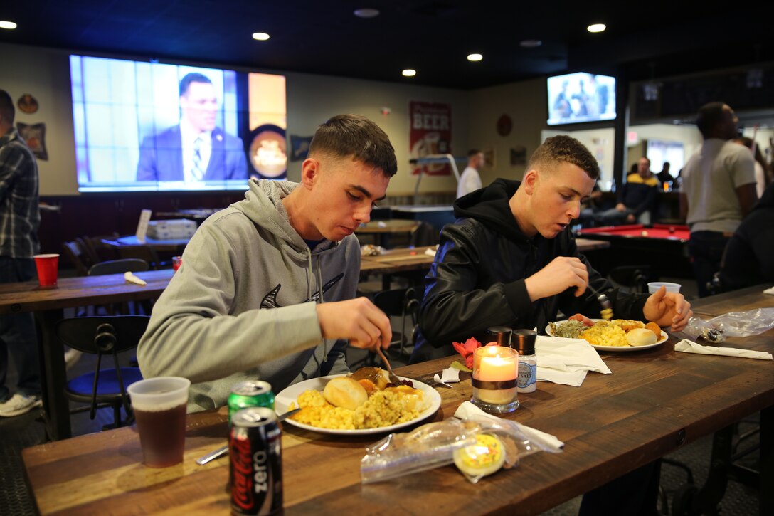 Pfc. Clark Boothe, left, and Pfc. Tanner Guillette enjoy a traditional homemade Thanksgiving meal during a Thanksgiving celebration at the Roadhouse at Marine Corps Air Station Cherry Point, N.C., Nov. 27, 2014. Service members from the air station who weren’t able to be with family for the holiday enjoyed time together eating, playing games and watching football. Boothe and Guillette are both students at the Center for Naval Aviation Technical Training.