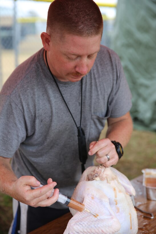 Cpl. Jonathan Klindt, prepares a turkey before serving Marines with Marine Wing Support Squadron 271 a Thanksgiving meal at Marine Corps Air Station Cherry Point, N.C., Nov. 26, 2014. The meal was held to reward single Marines for their hard work during the year. The Marines also collected canned goods for families in the community for the holiday season. Klindt is an engineer equipment mechanic with MWSS-271. 