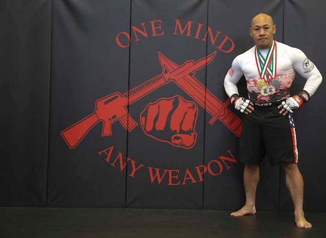 Major Jackson Doan, operation officer, Edson Range, Weapons Field Training Battalion, Marine Corps Base Camp Pendleton, stands with medals and Pankration World Title Belt at Marine Corps Base Camp Pendleton, Nov. 19. Doan is an Oceanside, Calif., native and is the current Pankration World Champion in the 145 pound weight class.