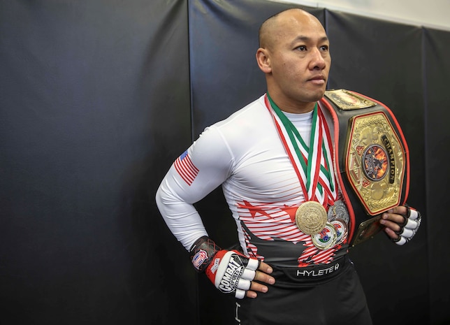 Major Jackson Doan, operation officer, Edson Range, Weapons Field Training Battalion, Marine Corps Base Camp Pendleton, stands with medals and his Pankration World Title Belt at Marine Corps Base Camp Pendleton, Nov. 19. Doan is an Oceanside, Calif., native and is the current Pankration World Champion in the 145 pound weight class.