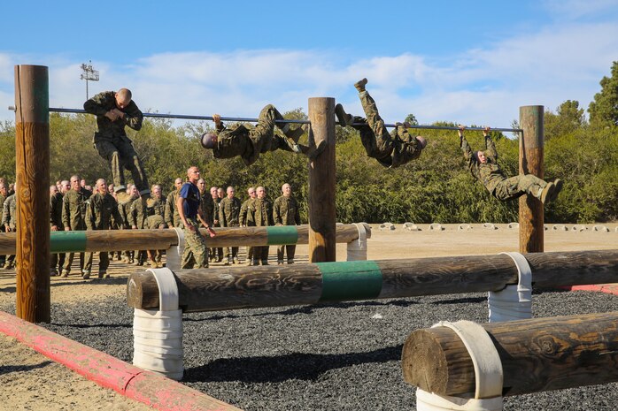Recruits of Lima Company, 3rd Recruit Training Battalion, pull themselves over a high bar during the Obstacle Course II event aboard Marine Corps Recruit Depot San Diego, Nov. 20.  Recruits were taught two techniques to overcome the first high bar; the ‘chicken-wing’ and the ‘college boy roll.’