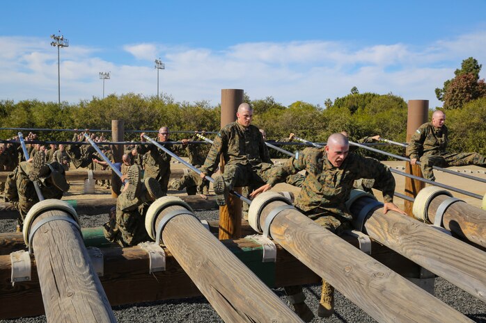 Recruits of Lima Company, 3rd Recruit Training Battalion, slide across a poll and then balance across a set of logs during the Obstacle Course II event aboard Marine Corps Recruit Depot San Diego, Nov. 20.  The obstacles help prepare recruits for the unknown challenges they may run into while out in a combat situation.