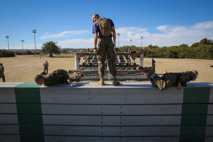 Sgt. David Mikulec, drill instructor, Lima Company, 3rd Recruit Training Battalion, ensures recruits keep a low profile while jumping over a high-wall during the Obstacle Course II event aboard Marine Corps Recruit Depot San Diego, Nov. 20.  Drill instructors were stationed throughout the course to make sure proper safety and techniques were executed at each obstacle.