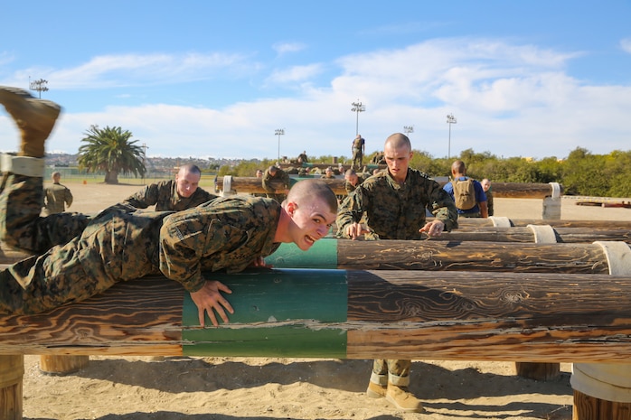 Recruits of Lima Company, 3rd Recruit Training Battalion, jump over logs while keeping a low profile during the Obstacle Course II event aboard Marine Corps Recruit Depot San Diego, Nov. 20.  Recruits had an idea of what to expect this time around, as this was the second time they went through, but the course was still able to test their physical and mental strength.