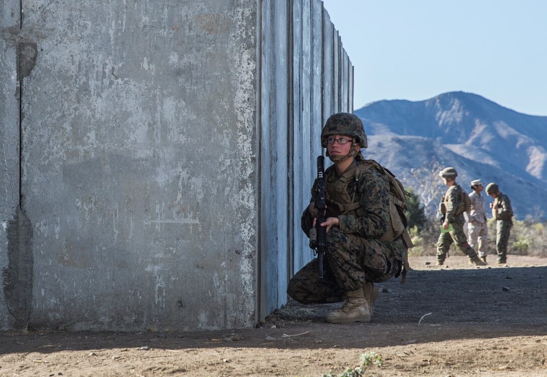 U.S. Marine Pfc. Chevon Ferrell-Collard posts security while evacuees are escorted to a safe location during a simulated noncombatant evacuation operation Camp Pendleton, Calif., Nov. 19, 2014. Ferrell-Collard is an ammunition technician with Combat Logistics Battalion 15, 15th Marine Expeditionary Unit. The training is designed to improve Marines’ tactics in assisting the Department of State in evacuating U.S. citizens and civilian personnel from foreign nations to an appropriate safe haven. (U.S. Marine Corps photo by Sgt. Emmanuel Ramos/Released)