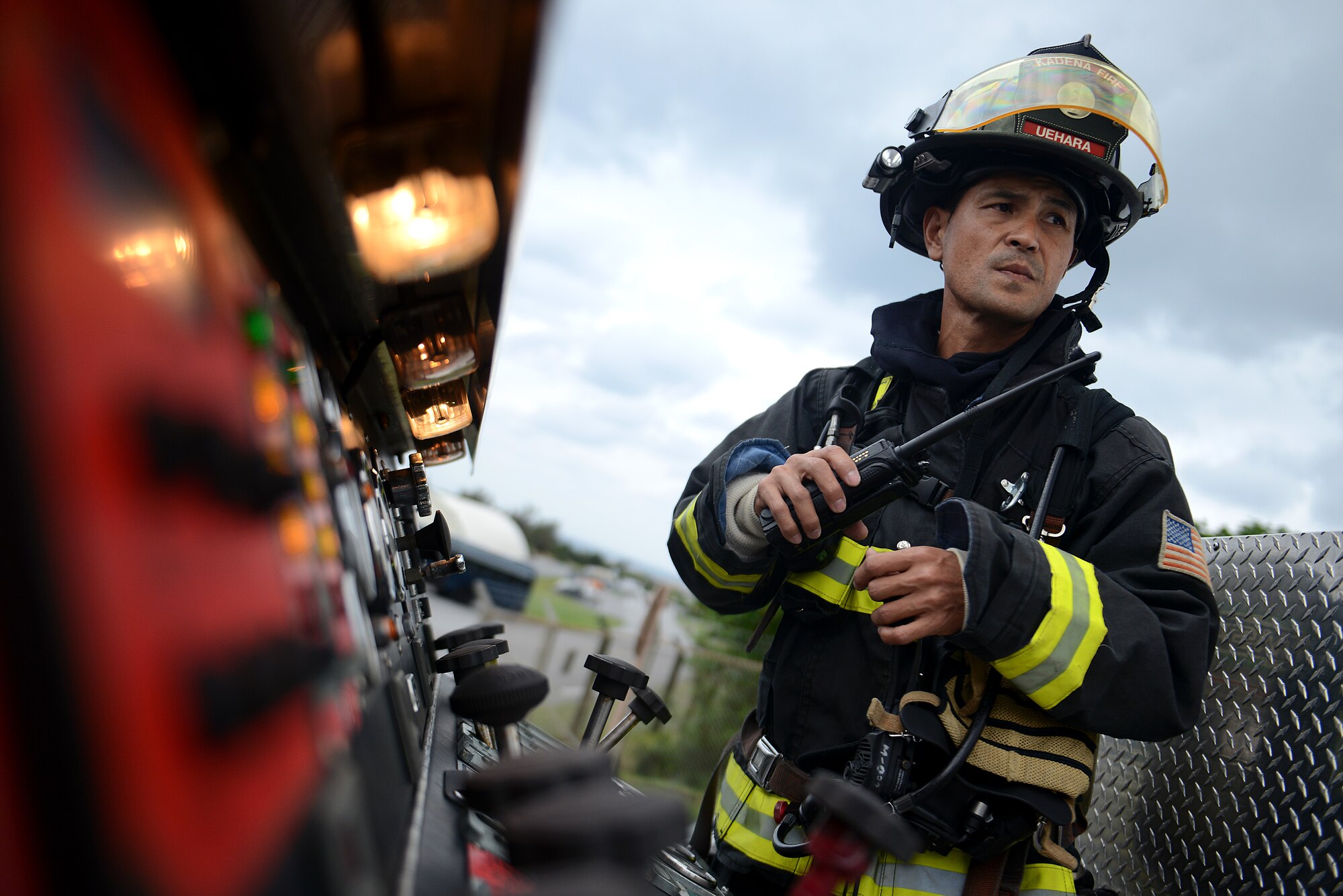 Keita Uehara, 18th Civil Engineer Squadron firefighter, listens to the radio atop a fire truck during a simulated hazardous materials vehicle crash as part of a mission focused exercise on Kadena Air Base, Japan, Dec. 2, 2014. The MFE, which tests Airmen on their ability to survive and operate in a multitude of stressful environments, is scheduled to run through Dec. 4. (U.S. Air Force photo by Senior Airman Maeson L. Elleman/Released) 