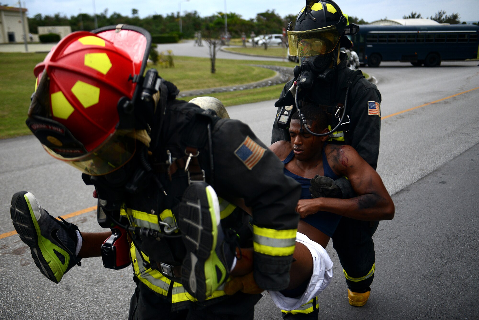 U.S. Air Force firefighters from the 18th Civil Engineer Squadron carry a victim of a simulated hazardous materials vehicle crash away from the accident as part of a mission focused exercise on Kadena Air Base, Japan, Dec. 2, 2014. The exercise tested Kadena emergency responders from firefighters to security forces members and medical personnel on their ability to quickly administer life-saving techniques in a stressful environment.  (U.S. Air Force photo by Senior Airman Maeson L. Elleman/Released) 