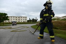 An 18th Civil Engineer Squadron firefighter stands ready with a fire hose during a simulated hazardous materials vehicle crash as part of a mission focused exercise on Kadena Air Base, Japan, Dec. 2, 2014. The MFE, which tests Airmen on their ability to survive and operate in a multitude of stressful environments, is scheduled to run through Dec. 4. (U.S. Air Force photo by Senior Airman Maeson L. Elleman/Released) 
