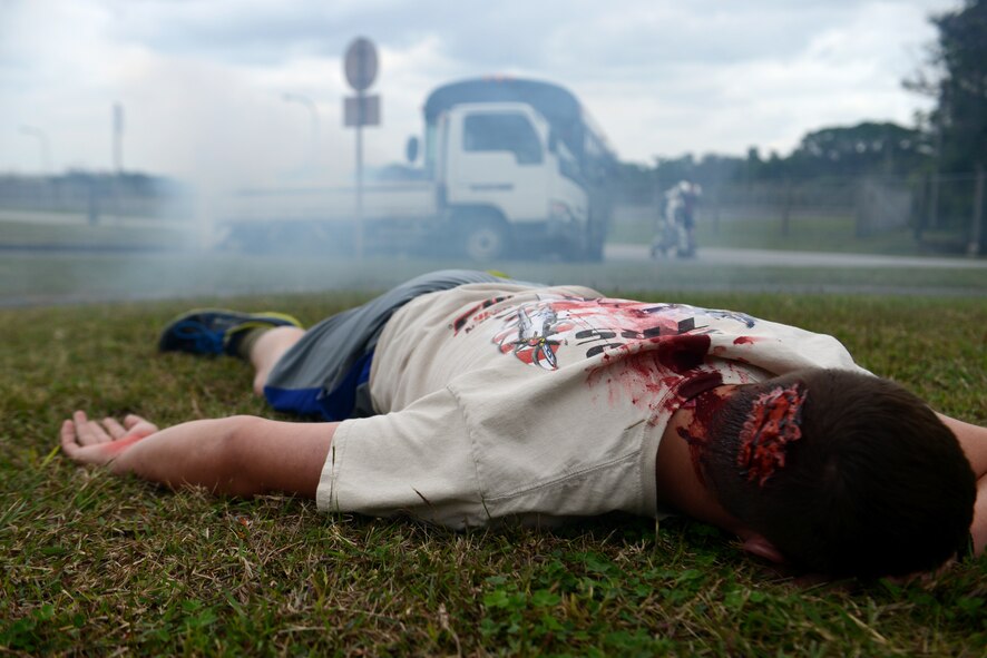 A victim of a simulated hazardous materials vehicle crash awaits emergency medical attention from 18th Civil Engineer Squadron firefighters as part of a mission focused exercise on Kadena Air Base, Japan, Dec. 2, 2014. The exercise tested Kadena emergency responders from firefighters to security forces members and medical personnel on their ability to quickly administer life-saving techniques in a stressful environment.  (U.S. Air Force photo by Senior Airman Maeson L. Elleman/Released) 
