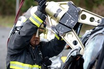 A Kadena firefighter from the 18th Civil Engineer Squadron uses a Hurst spreader to pry the top off a rolled-over vehicle during a simulated car accident as part of a mission focused exercise on Kadena Air Base, Japan, Dec. 2, 2014. The exercise tested Kadena emergency responders from firefighters to security forces members and medical personnel on their ability to quickly administer life-saving techniques in a stressful environment. (U.S. Air Force photo by Senior Airman Maeson L. Elleman/Released)