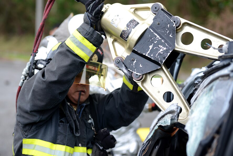 A Kadena firefighter from the 18th Civil Engineer Squadron uses a Hurst spreader to pry the top off a rolled-over vehicle during a simulated car accident as part of a mission focused exercise on Kadena Air Base, Japan, Dec. 2, 2014. The exercise tested Kadena emergency responders from firefighters to security forces members and medical personnel on their ability to quickly administer life-saving techniques in a stressful environment. (U.S. Air Force photo by Senior Airman Maeson L. Elleman/Released)