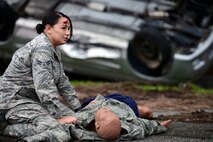 A simulated car accident victim waits beside a training mannequin for emergency first responders during a mission focused exercise on Kadena Air Base, Japan, Dec. 2, 2014. The MFE, which tests Airmen on their ability to survive and operate in a multitude of stressful environments, is scheduled to run through Dec. 4. (U.S. Air Force photo by Senior Airman Maeson L. Elleman/Released)