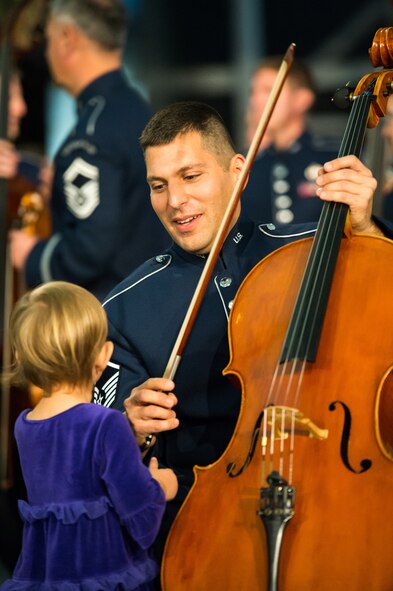 Master Sgt. Joshua Kowalsky, United States Air Force Concert Band cellist, talks with his daughter after their flash mob at the Smithsonian National Air and Space Museum Udvar-Hazy Center in Chantilly, Va., Dec. 2, 2014. The band’s mission is to honor those who have served, inspire American citizens to heightened patriotism and service, and positively impact the global community on behalf of the U.S. Air Force and America. (U.S. Air Force photo/ Staff Sgt. Devon Suits)