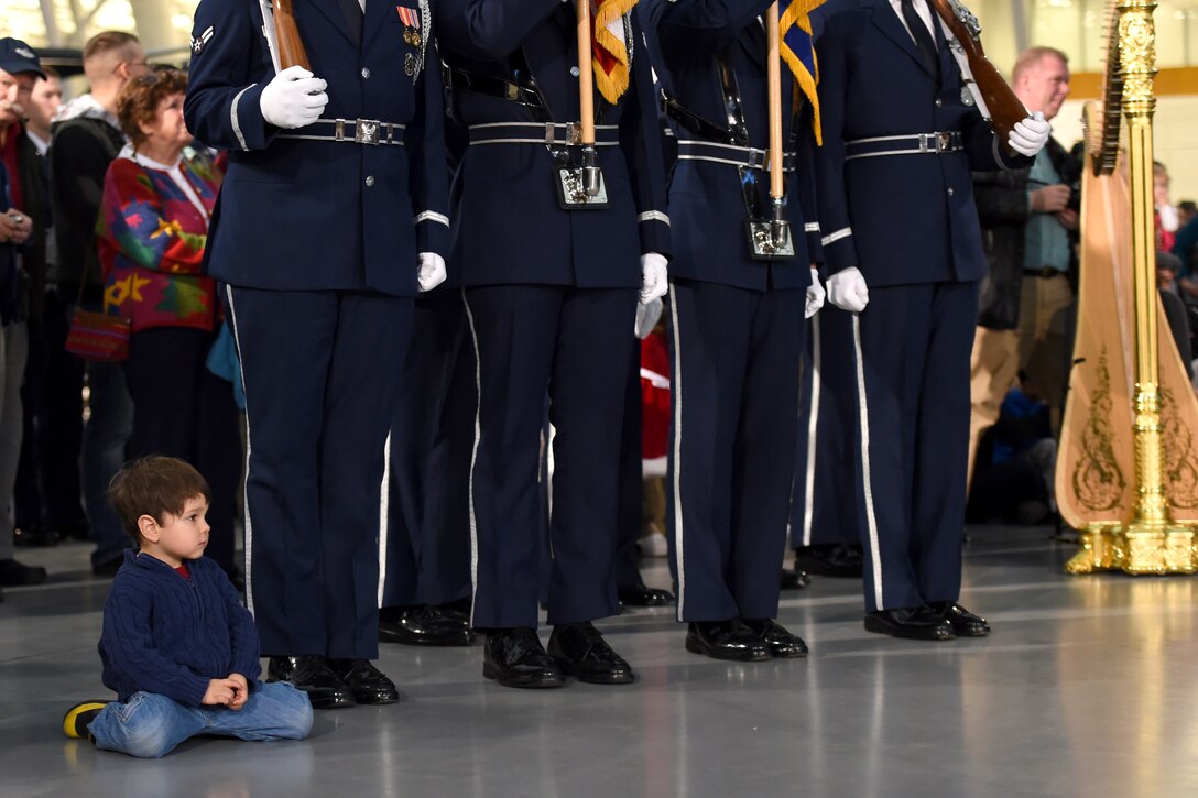 A boy watches the United States Air Band perform during a flash mob at the Smithsonian National Air and Space Museum Udvar-Hazy Center in Chantilly, Va., Dec. 2, 2014. The band put on the event to promote their upcoming holiday concerts in the National Capital Region.  (U.S. Air Force photo/ Senior Airman Nesha Humes)