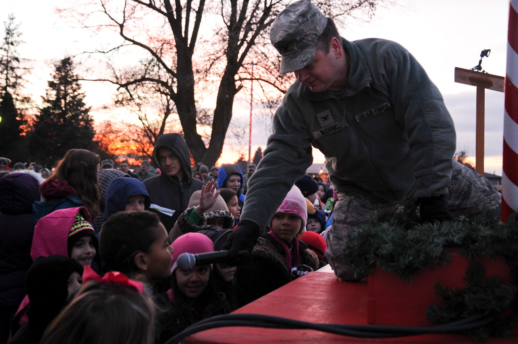 Col. Brian McDaniel, 92nd Air Refueling Wing commander, interacts with children during the annual tree lighting ceremony Dec. 1, 2014, at Fairchild Air Force Base, Wash. The children took turns saying what Christmas means to them. (U.S. Air Force photo/Airman 1st Class Nicolo J. Daniello)