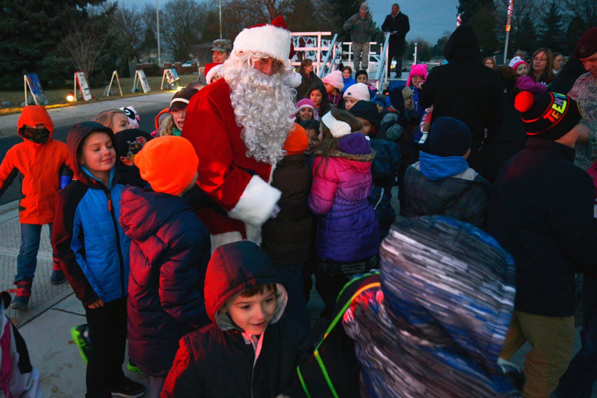 Children gather around Santa during his arrival at the annual tree lighting ceremony Dec. 1, 2014, at Fairchild Air Force Base, Wash. Santa’s arrival at the base chapel concluded the ceremony. (U.S. Air Force photo/Airman 1st Class Janelle Patiño)